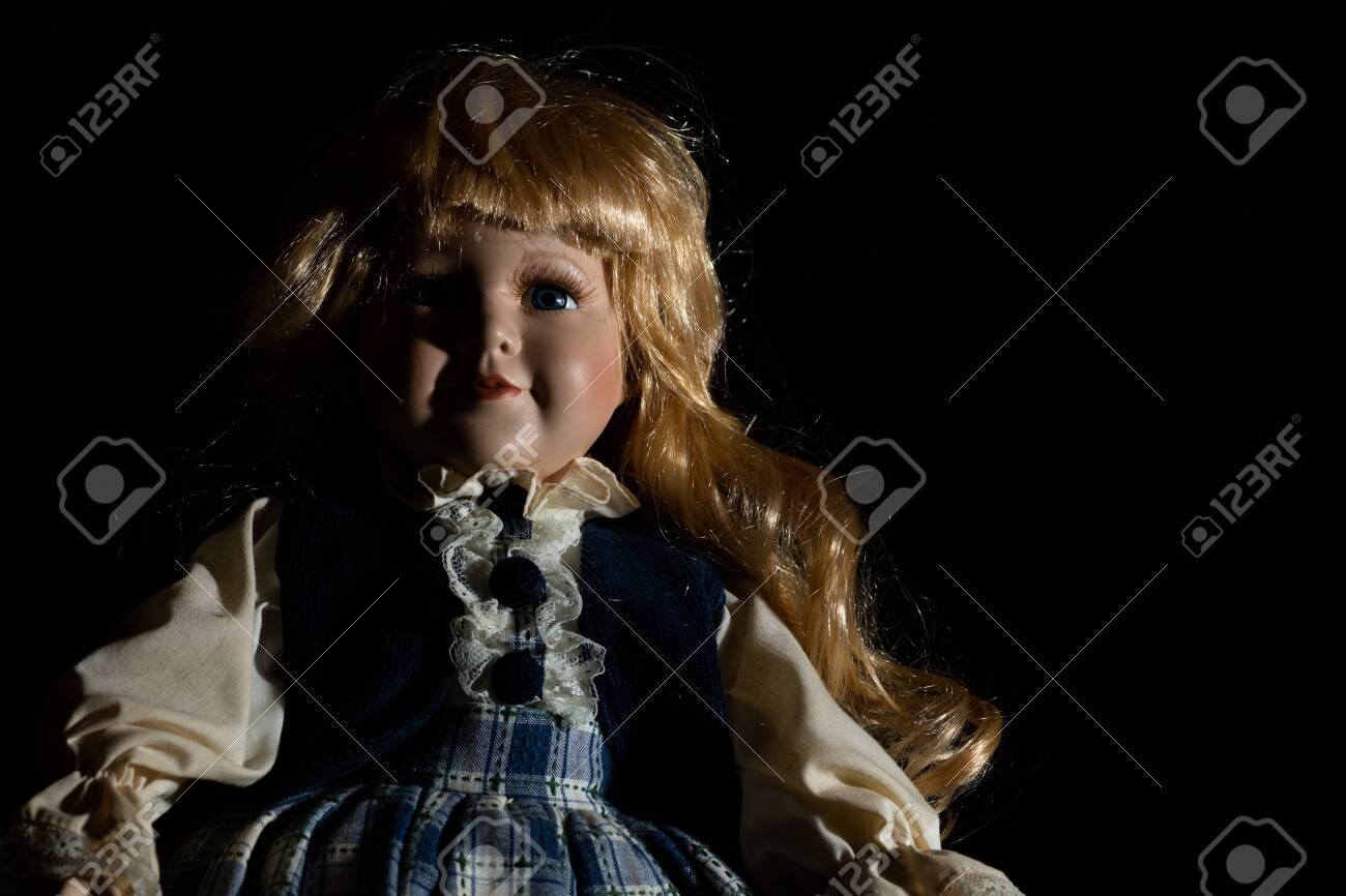 Creepy Porcelain Doll In A Black Background Stock Photo, Picture And  Royalty Free Image. Image 137084108.
