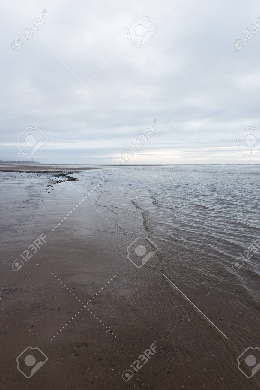 リラックスして穏やかな心を落ち着かせる波暗い曇りの日にビーチに流れる の写真素材 画像素材 Image