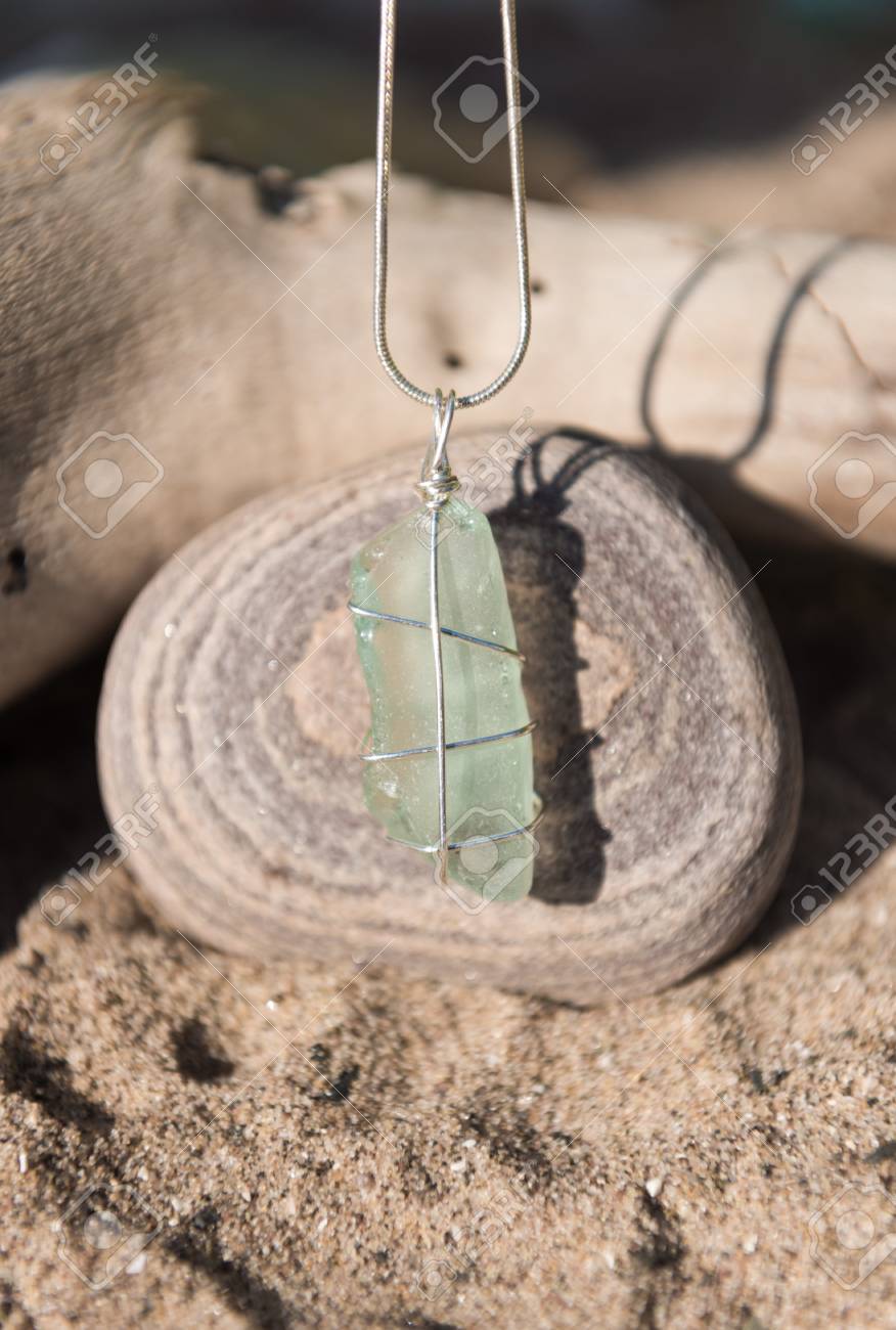 Hecha A Mano única Del Vidrio Del Mar Azul De La Aguamarina, Con Una Cadena De Plata Que Se Sobre Una Piedra Del Mar. Fotos, Retratos, Imágenes Y Fotografía De