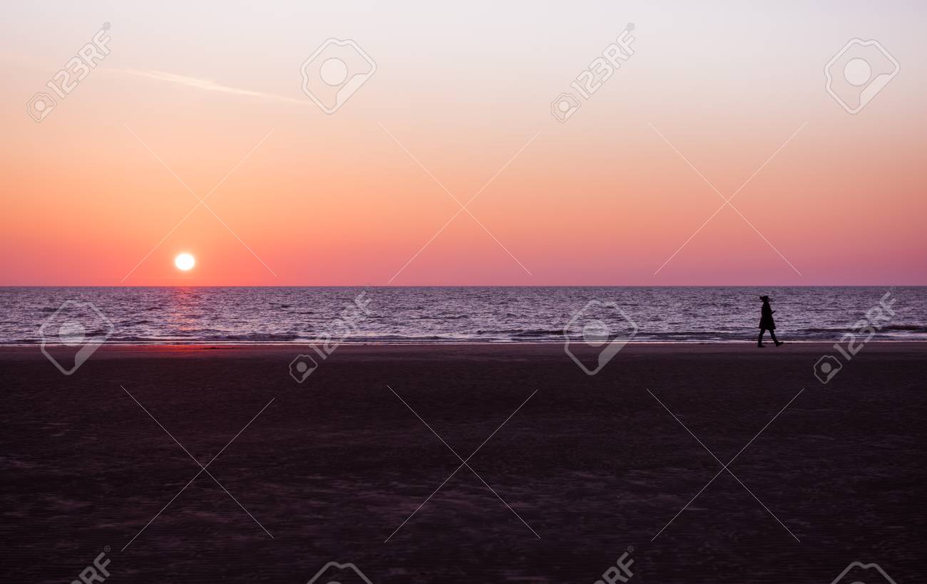 鮮やかな深い紫色とピンク ロサンゼルス サンセット リラックスした静かな夕日の海岸散歩女性シルエット の写真素材 画像素材 Image