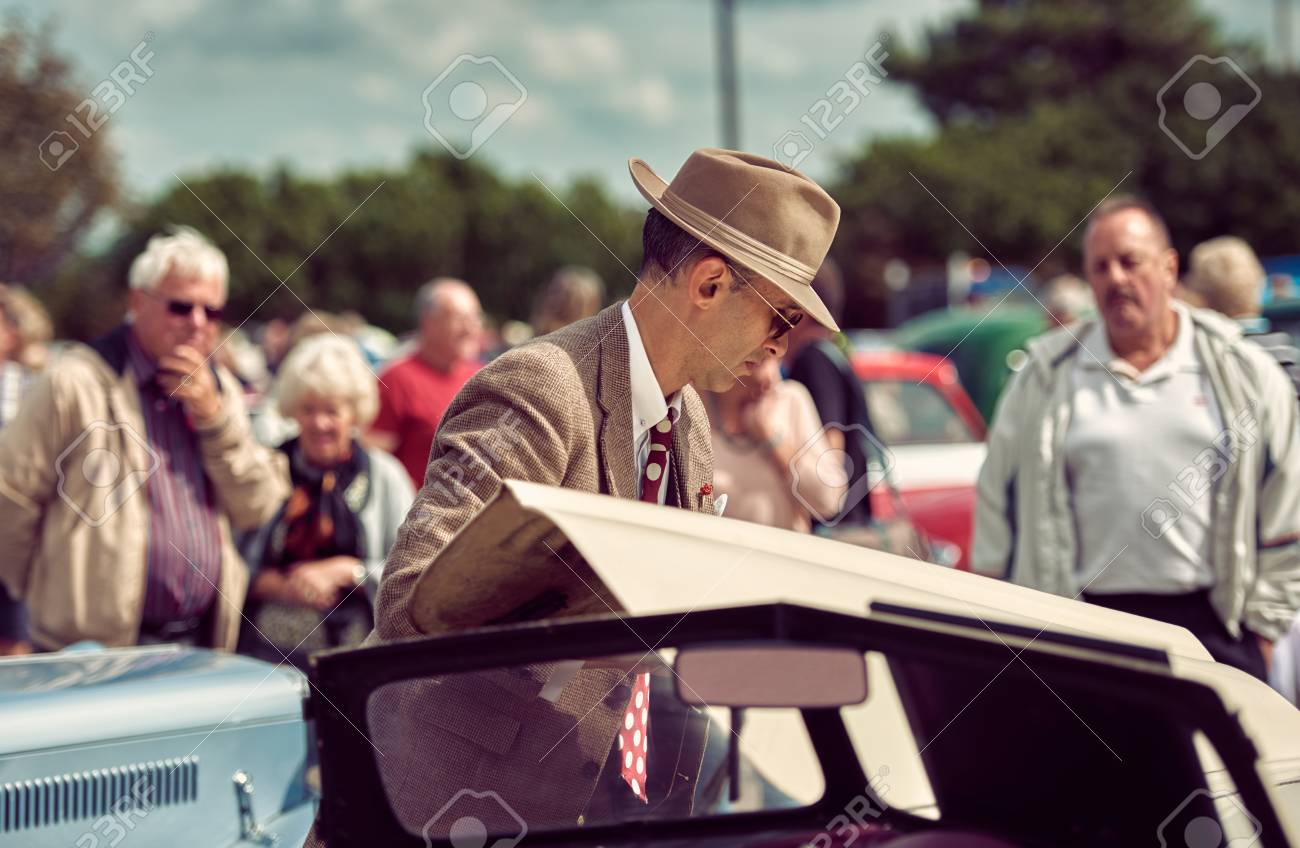 ロンドン イングランド 05 05 17 古い車の骨の下を見て 帽子 ウエストコートとメガネでスタイリッシュなレトロなヴィンテージファッショナブルな男 古い アメリカの映画ノワール探偵インスペクタースタイルの服 の写真素材 画像素材 Image