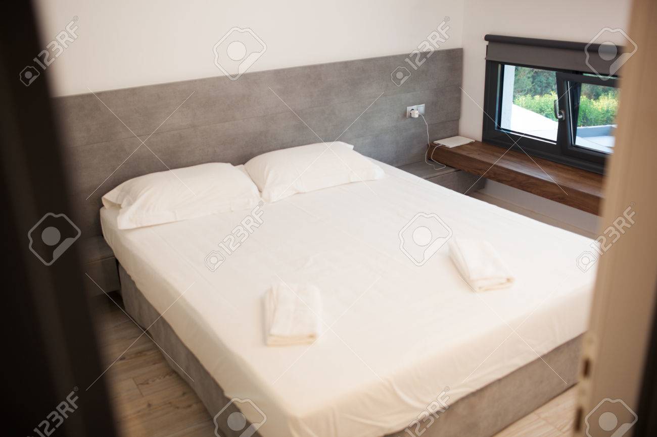 Empty Clean Hotel Room For Two With Matrimonial Bed In The Middle With  Comfortable Mattress Covered With White Tidy Sheet Stock Photo, Picture and  Royalty Free Image. Image 57008976., image size:1300x866