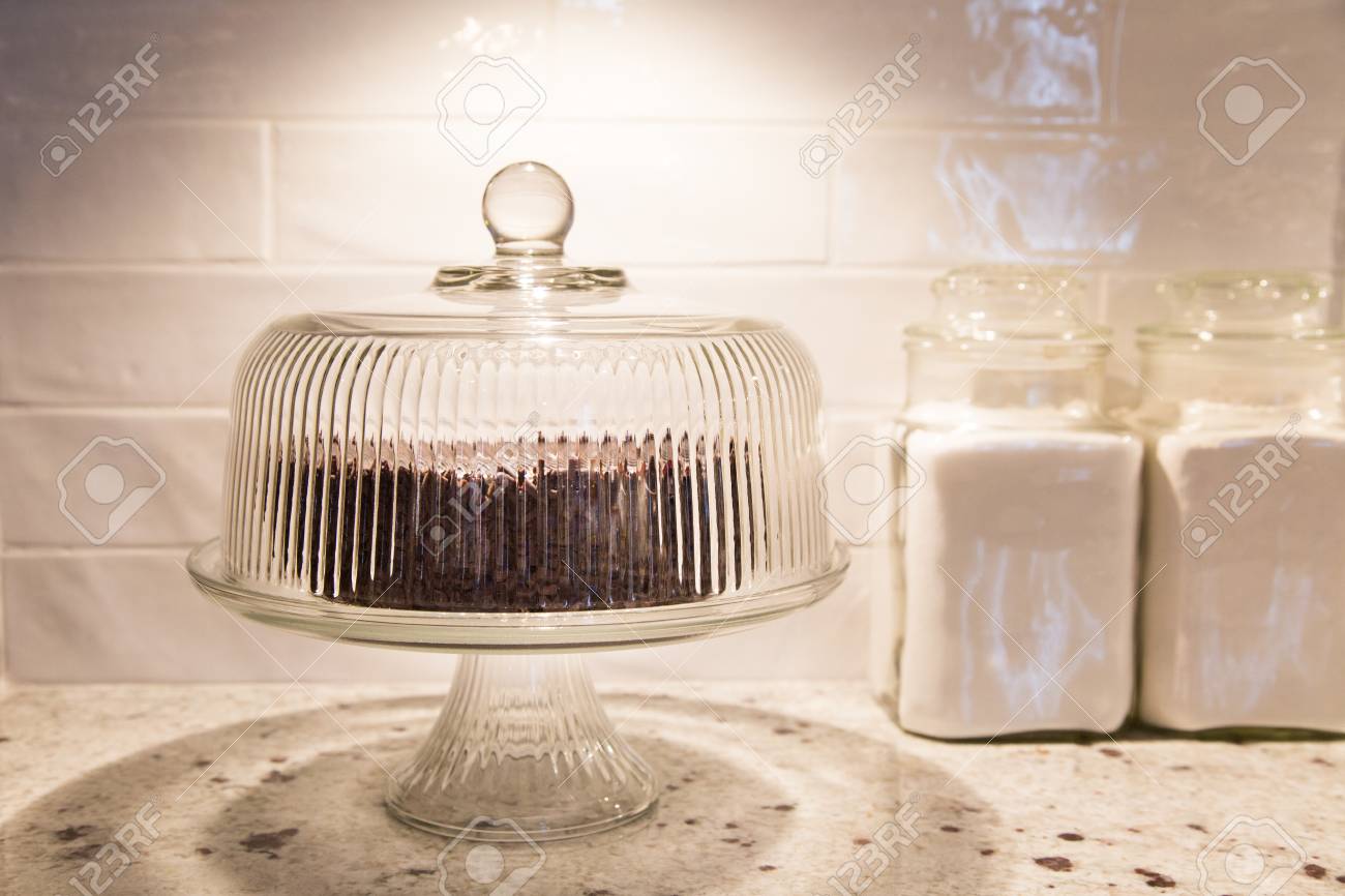 chocolate cake under a vintage glass cake dome with vintage canisters beside stock photo 78365857 - Glass Cake Dome chocolate cake under a vintage glass cake dome with vintage canisters beside stock photo 78365857 - Glass Cake Dome
