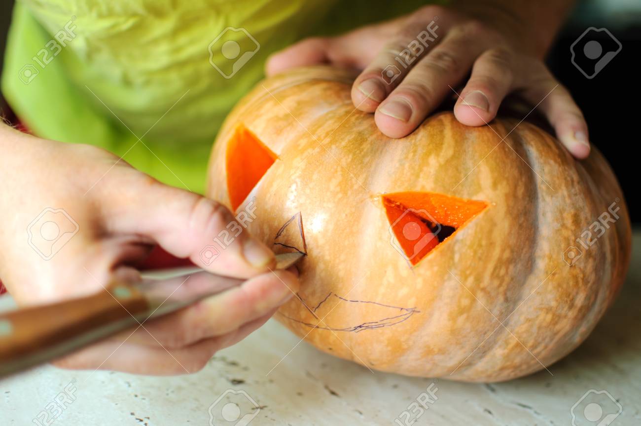 ハロウィーン カボチャ加工 ジャック O ランタンを作るプロセス 残り物かぼちゃキッチン テーブルの上のナイフで男性の手 選択と集中とボケ味 の写真 素材 画像素材 Image