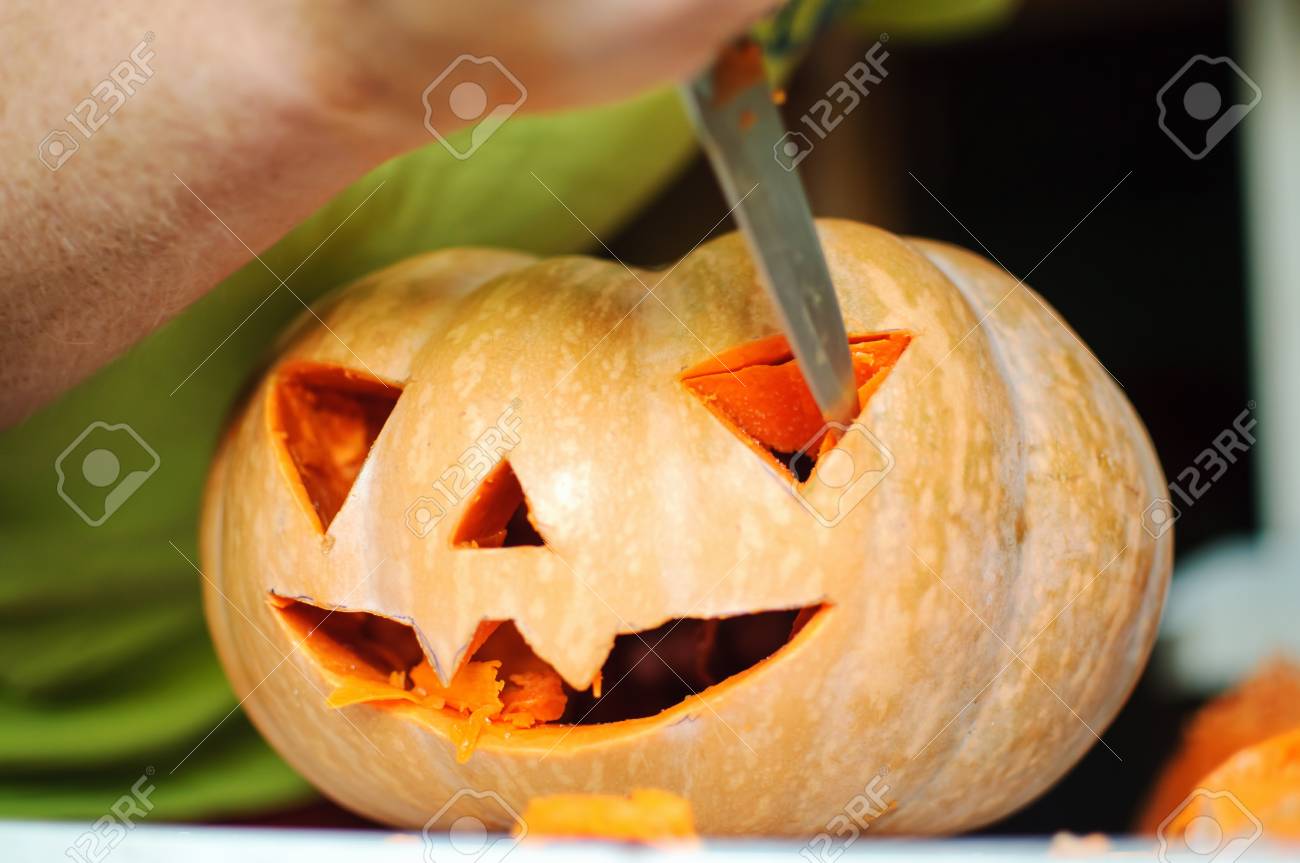 ハロウィーン カボチャ加工 ジャック O ランタンを作るプロセス 残り物かぼちゃキッチン テーブルの上のナイフで男性の手 選択と集中とボケ味 の写真 素材 画像素材 Image