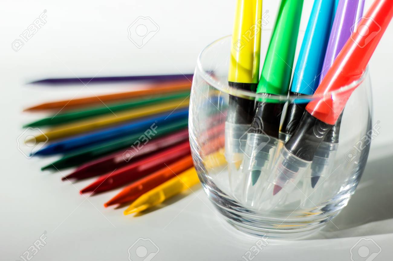 drawing utensils colorful crayon pencil and markers in a glass