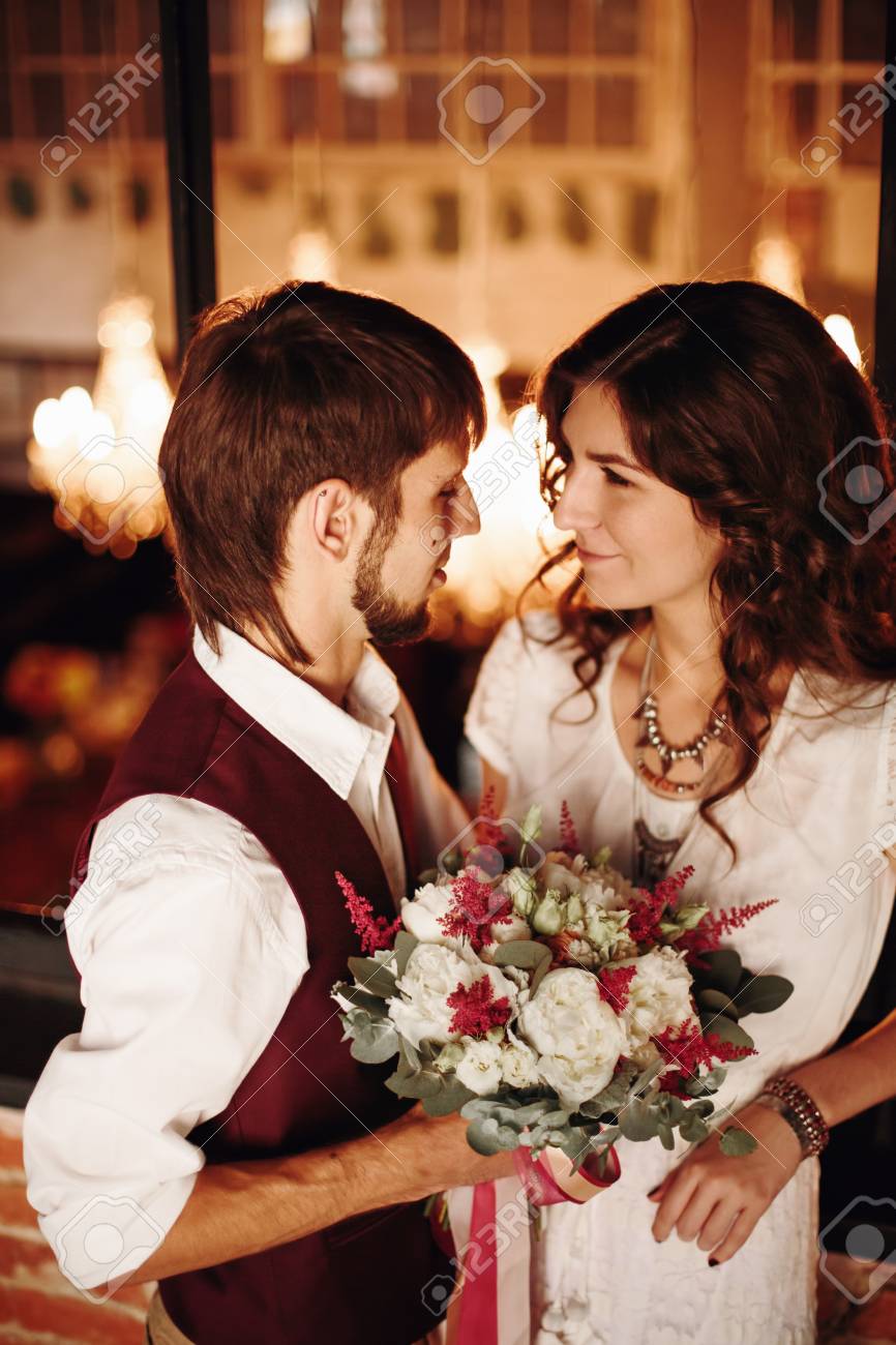 スタイリッシュな結婚式のカップル 新郎と花嫁と花 立って一緒に抱きしめると ロフトのインテリアでキスします 選択と集中 の写真素材 画像素材 Image 51910353