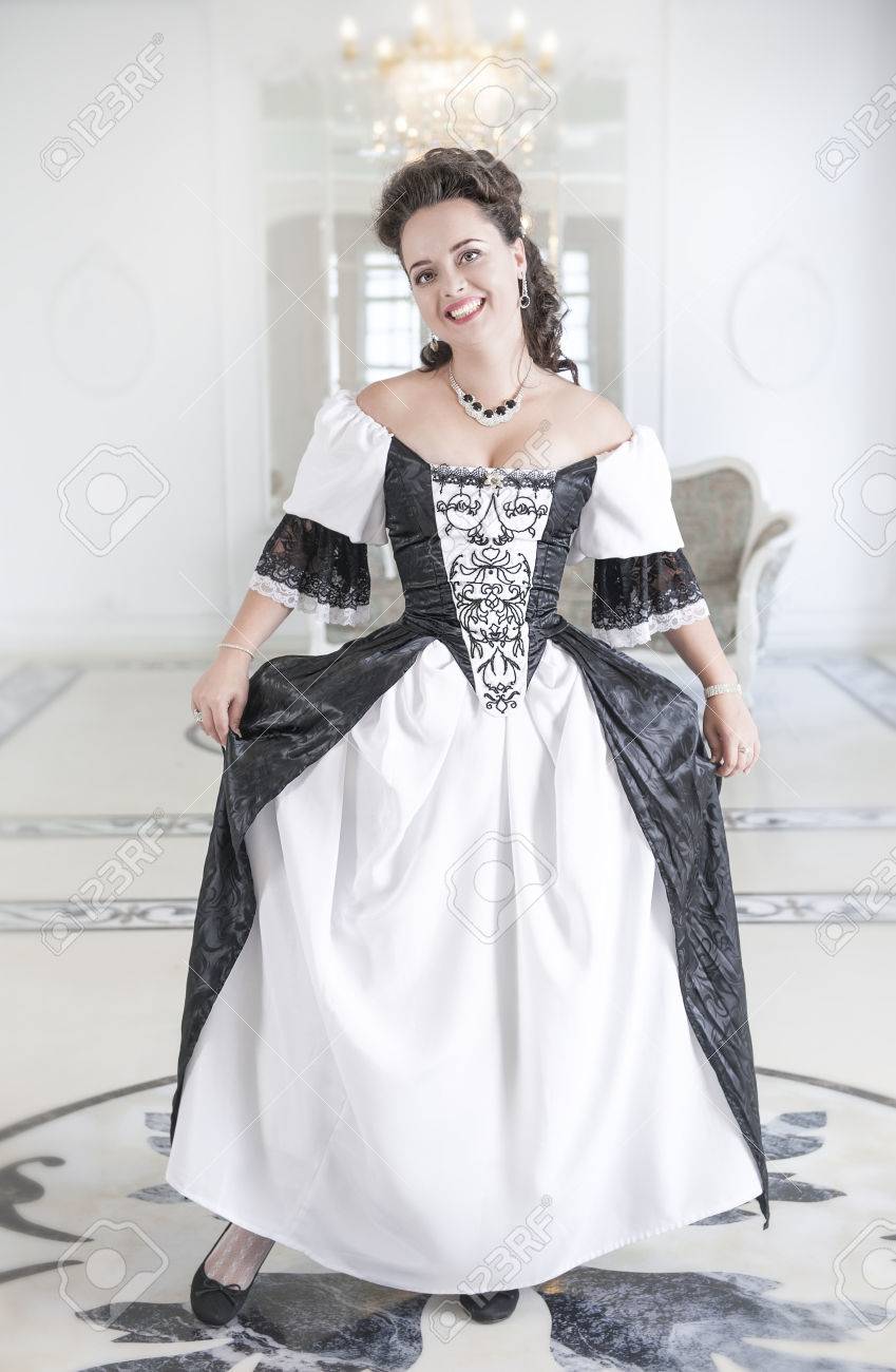 黒と白の長い中世のドレスを女性のおじぎの美しい若い女性 の写真素材 画像素材 Image