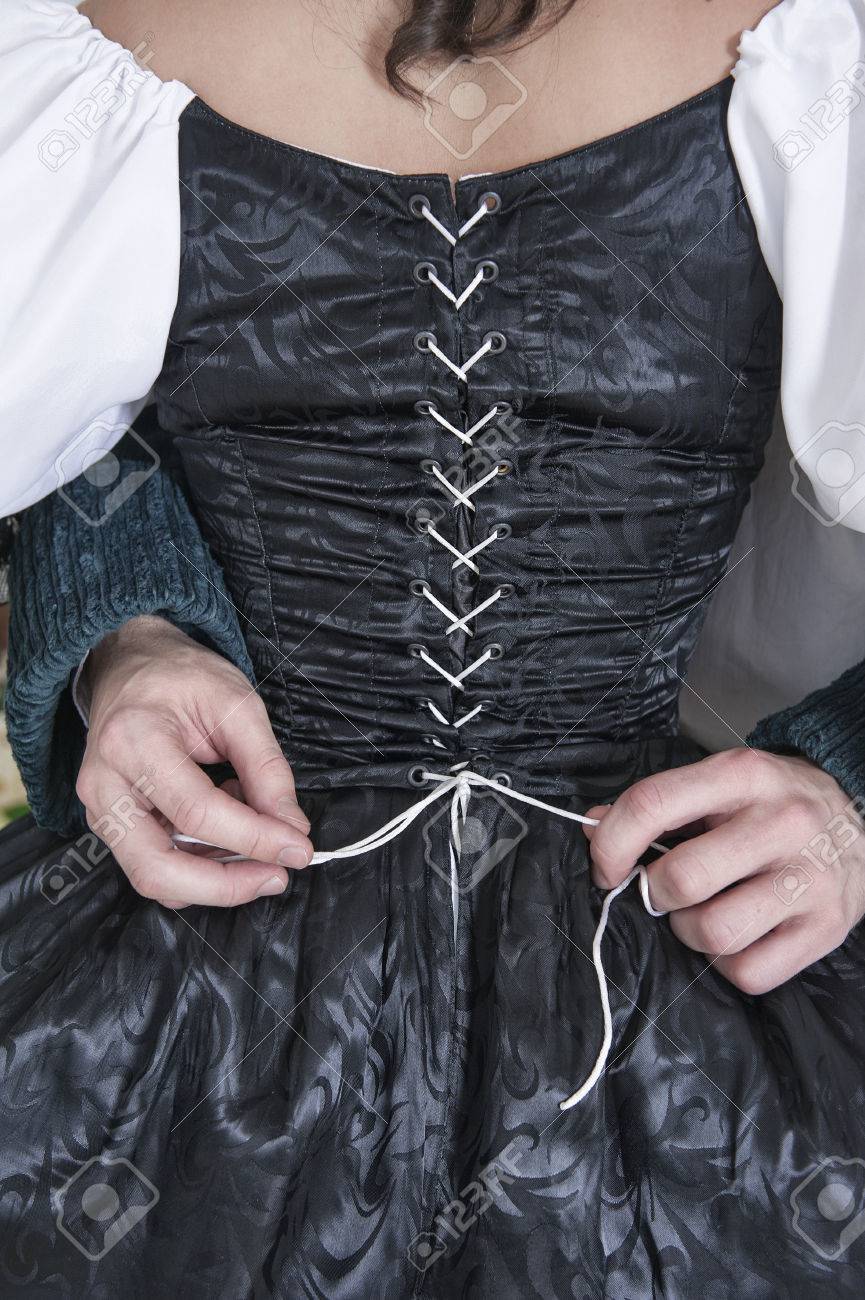 男の手の黒い中世のドレスを着た女性の帰宅のコルセット の写真素材 画像素材 Image