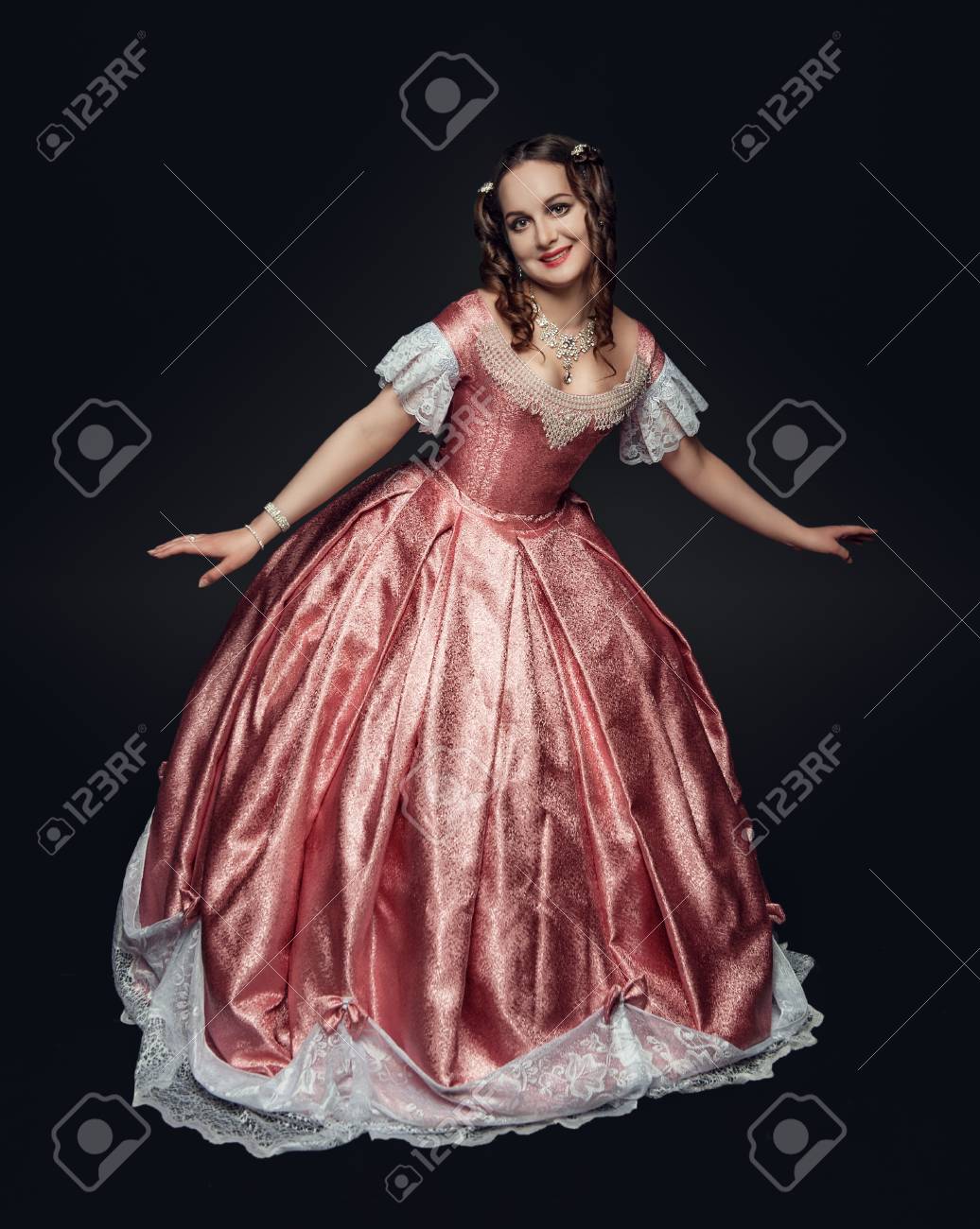 黒い背景におじぎをする中世のドレスを着た若い美しい女性 の写真素材 画像素材 Image