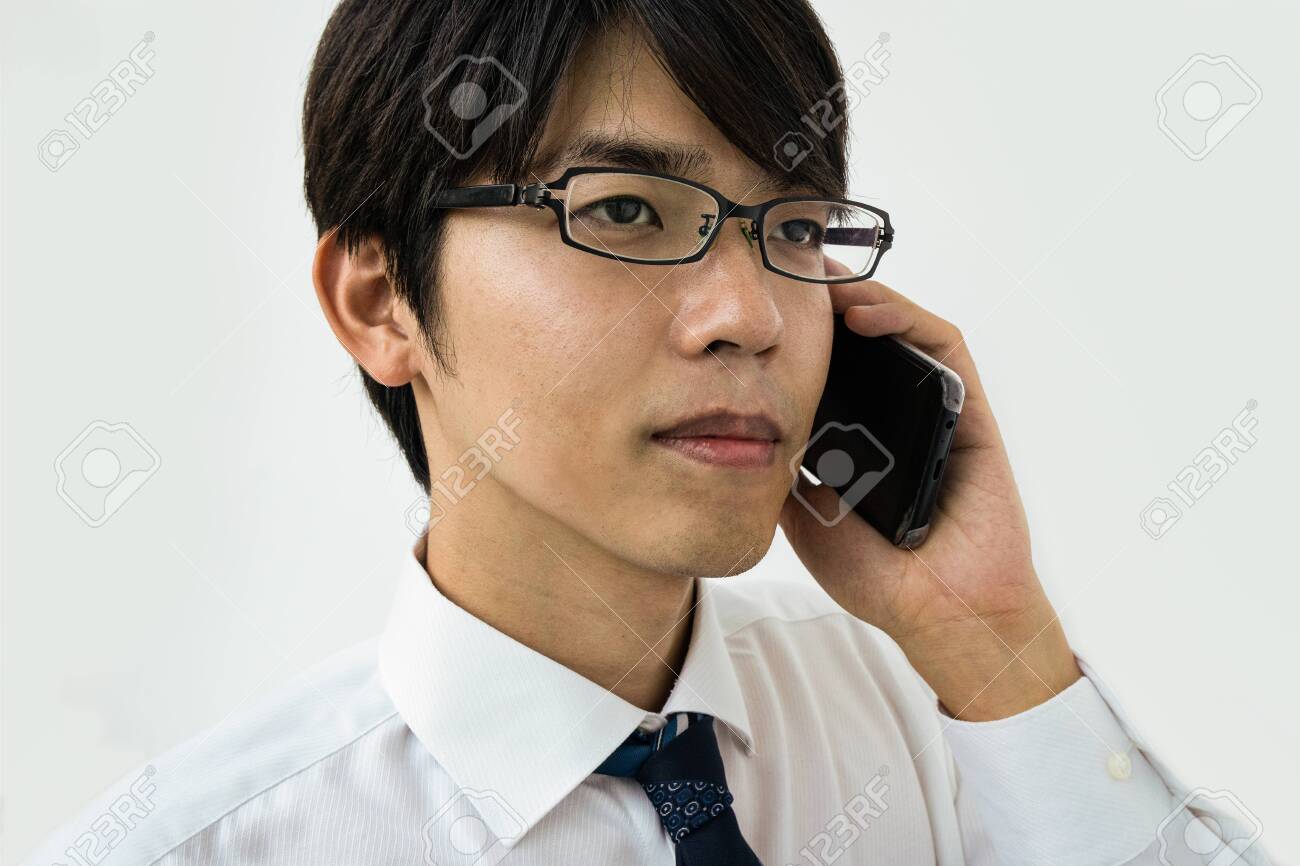 Young Japanese businessman talking on the phone. Isolated on white. - 149445800 Young Japanese businessman talking on the phone. Isolated on white. - 149445800