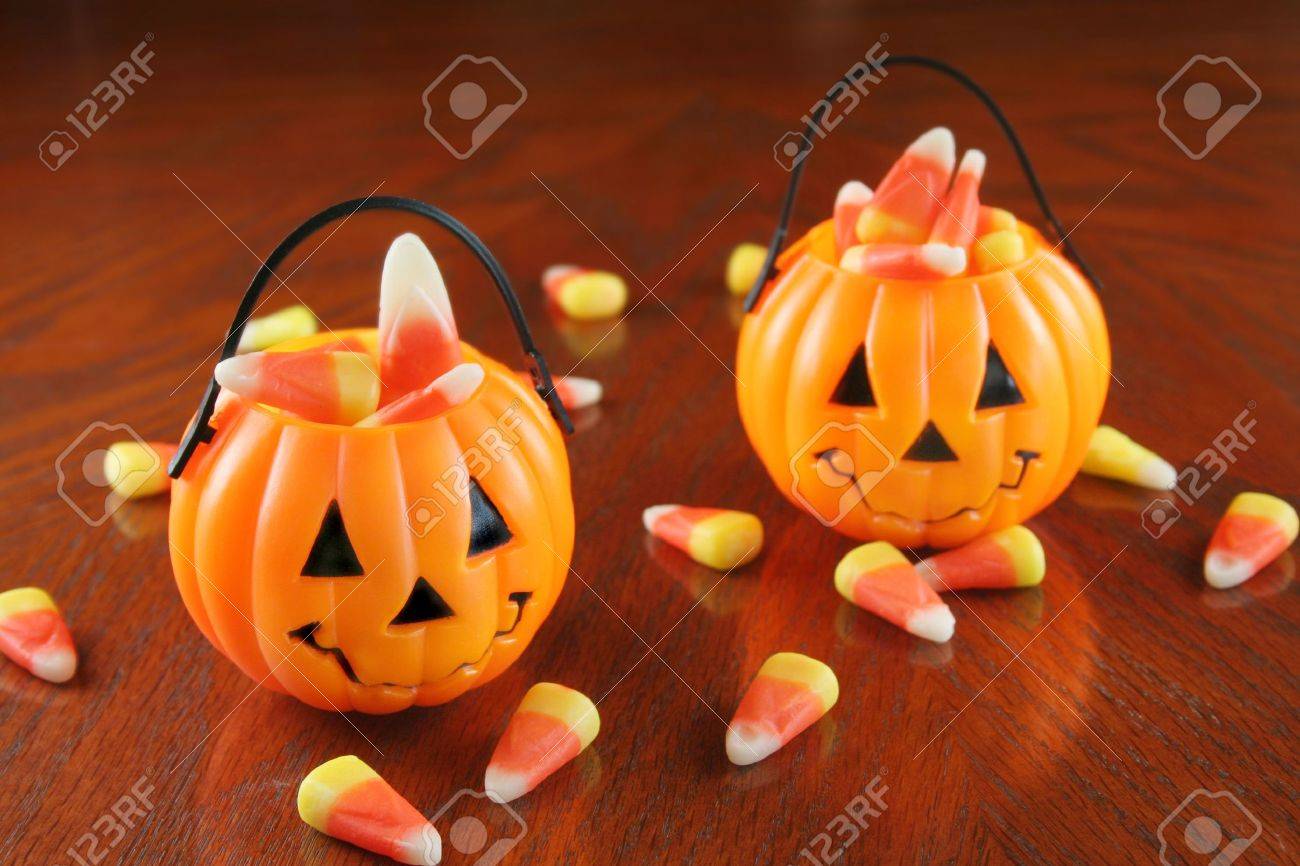 small plastic pumpkins holding candy corn with some laying on a table top stock photo - Plastic Pumpkins small plastic pumpkins holding candy corn with some laying on a table top stock photo - Plastic Pumpkins