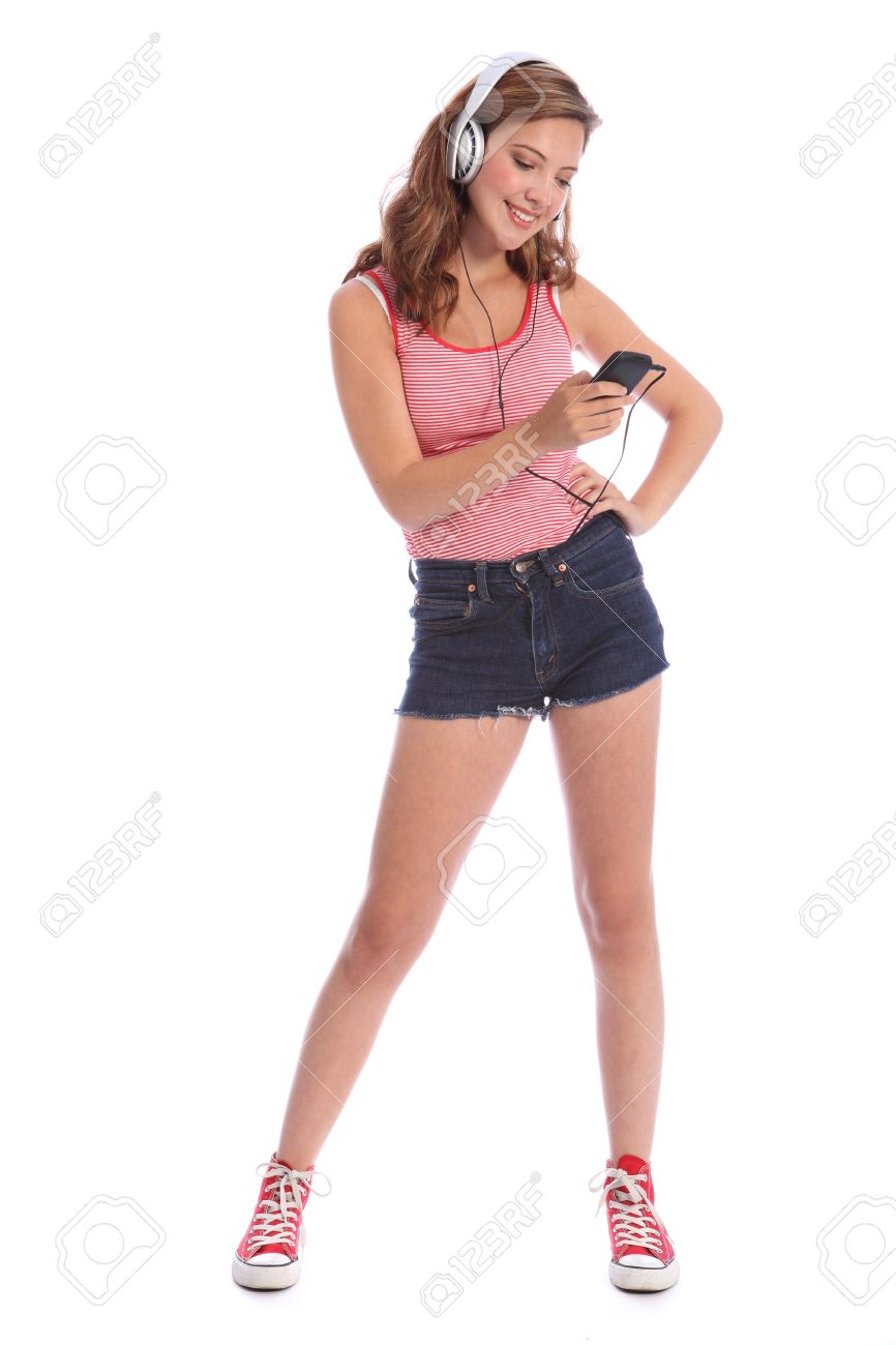 デニムを着て長い脚と美しい白人の 10 代の少女はカット ショート パンツ シルバーのヘッドフォンで音楽を聴く彼女の携帯電話を使用します の写真素材 画像素材 Image