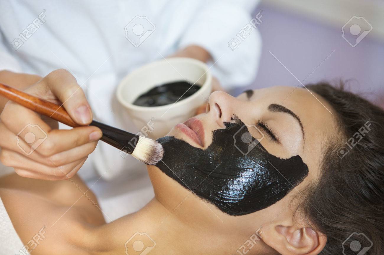 Young beautiful woman in a mask for the face of the therapeutic black mud. Spa treatment - 46965186 Young beautiful woman in a mask for the face of the therapeutic black mud. Spa treatment - 46965186