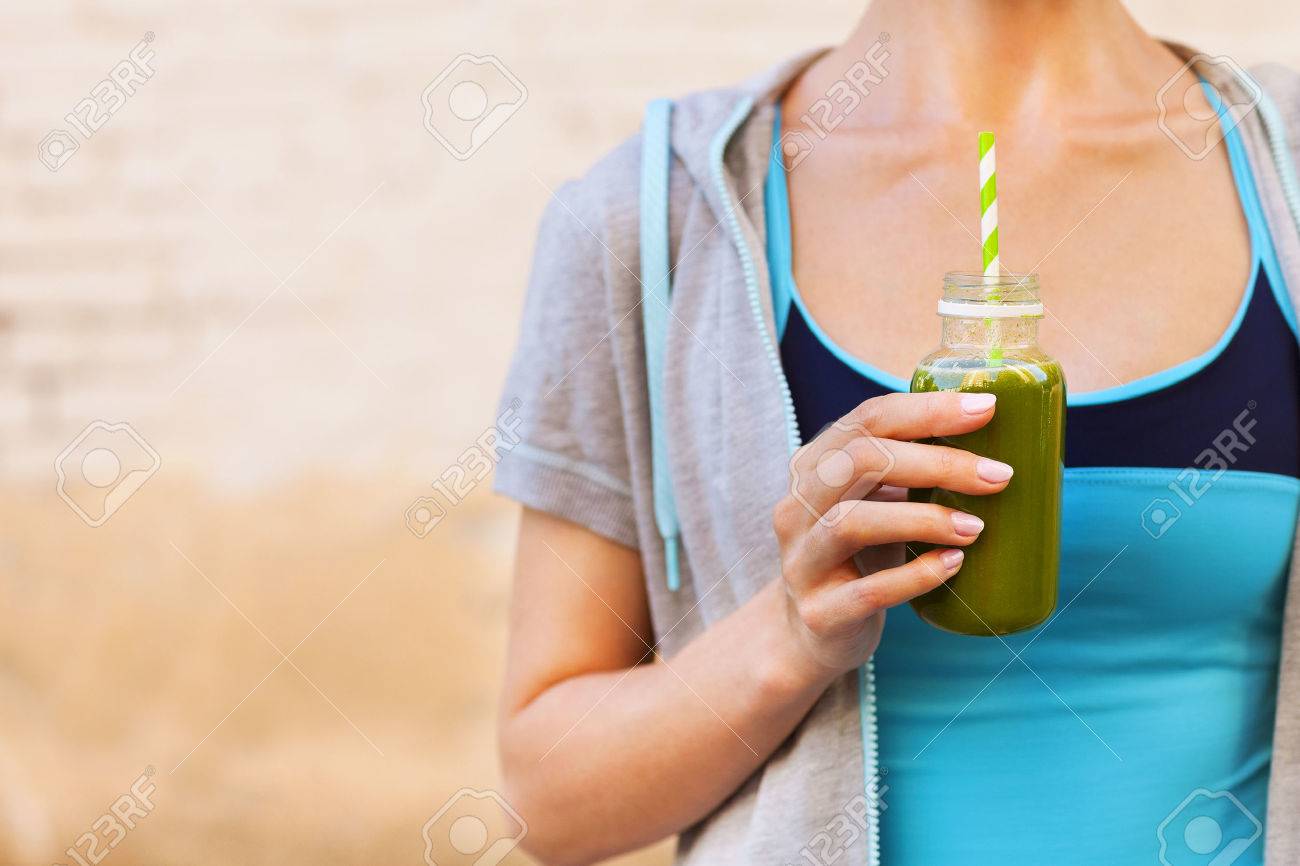 Woman drinking vegetable smoothie after fitness running workout on summer day. Fitness and healthy lifestyle concept - 50767283 Woman drinking vegetable smoothie after fitness running workout on summer day. Fitness and healthy lifestyle concept - 50767283