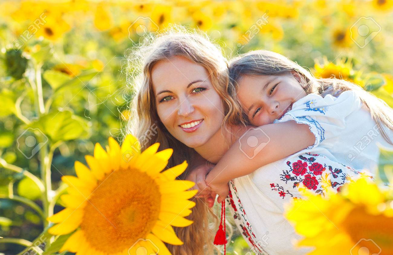 Happy mother and her little daughter in the sunflower field. Summer fun - 52315511 Happy mother and her little daughter in the sunflower field. Summer fun - 52315511