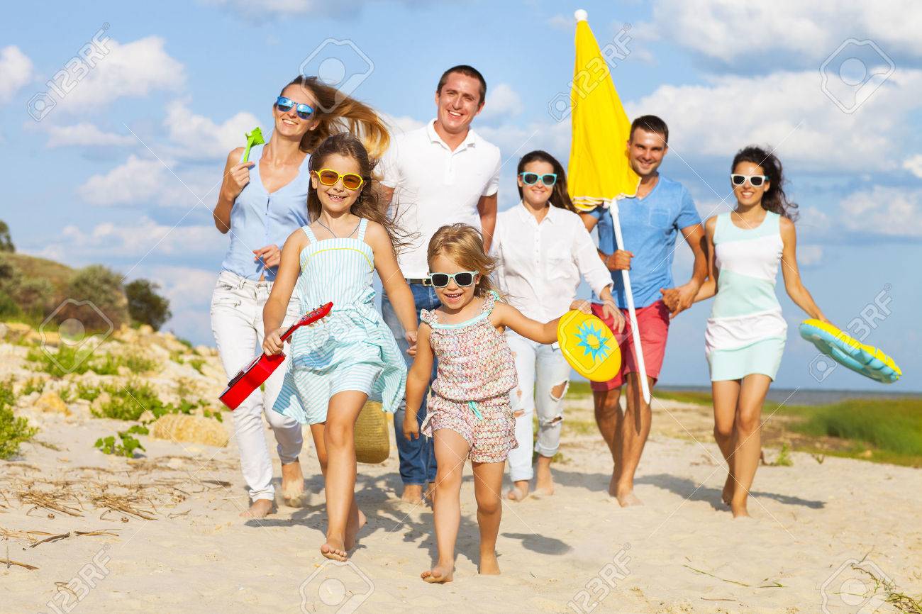 Multiracial group of friends with children running at the beach - 53019548 Multiracial group of friends with children running at the beach - 53019548