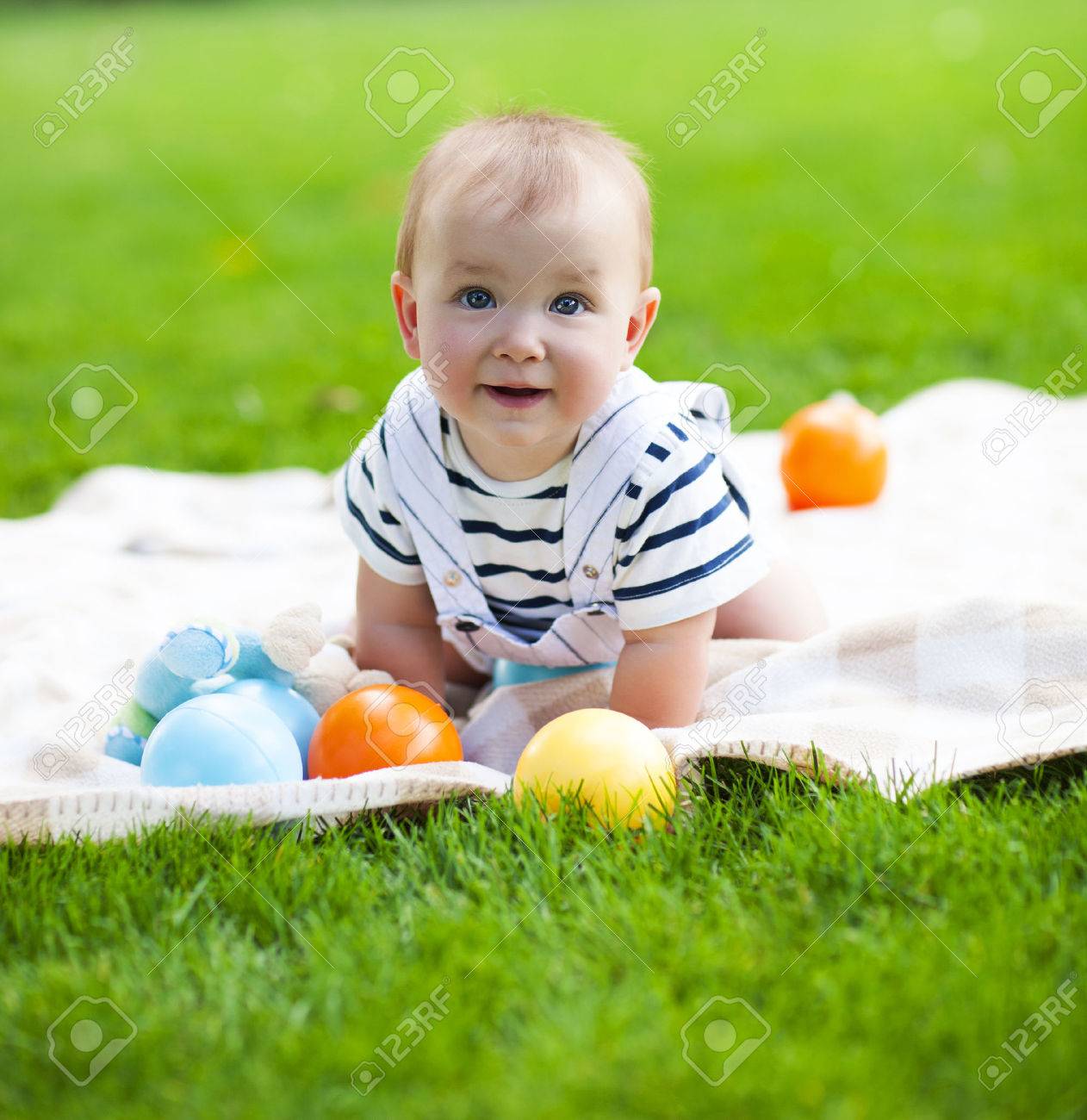 Close up portrait of the smiling baby boy playing outdoors - 54379904 Close up portrait of the smiling baby boy playing outdoors - 54379904