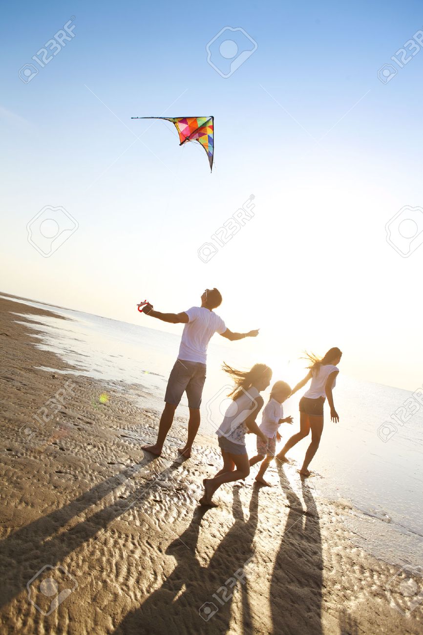 Happy young family with two kids with flying a kite on the beach - 55843852 Happy young family with two kids with flying a kite on the beach - 55843852