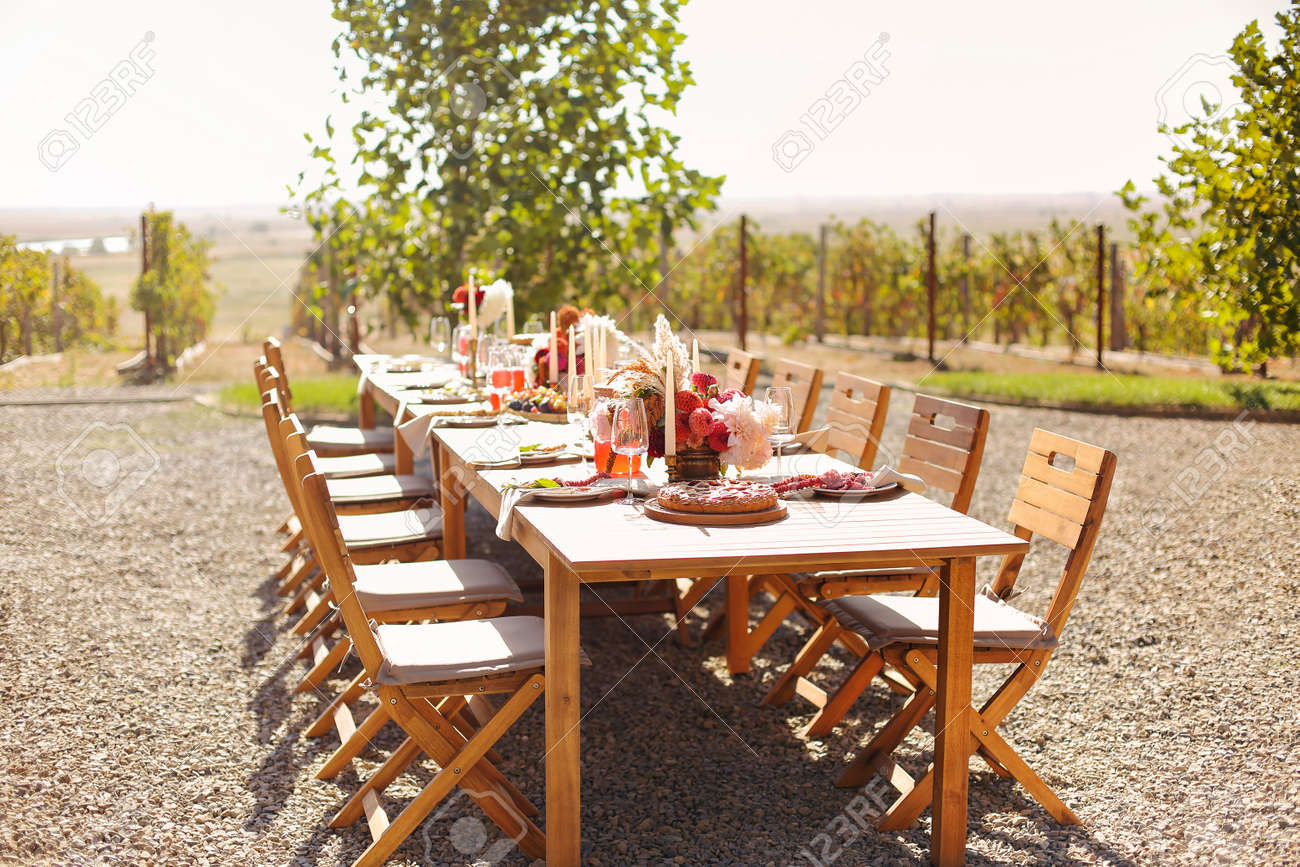Empty wineglass placed near board with fruits on banquet table on sunny summer day - 169389624 Empty wineglass placed near board with fruits on banquet table on sunny summer day - 169389624