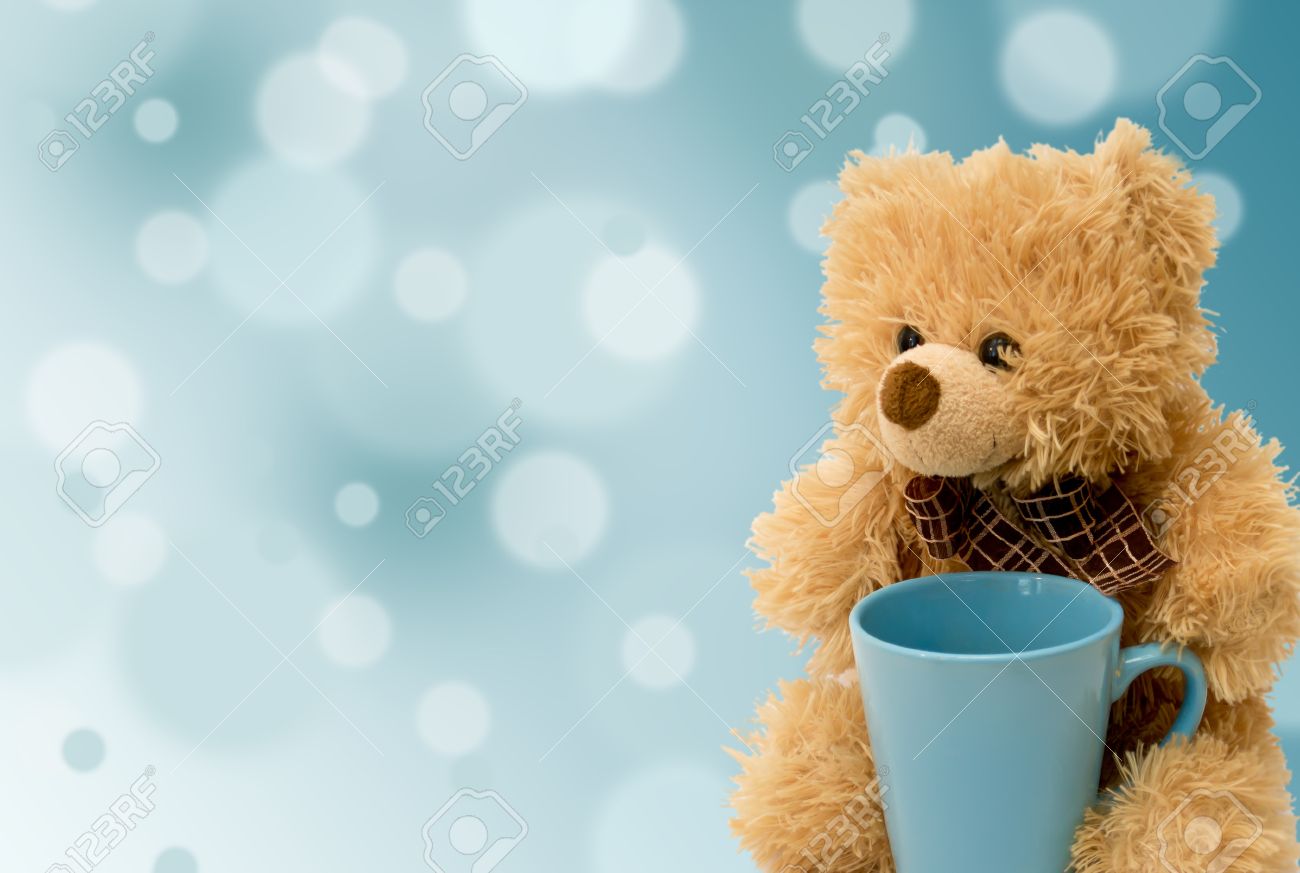 teddy bear with a blue cup on a blue background stock photo picture