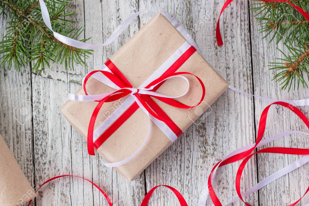 packing christmas presents in kraft paper with red and white stock