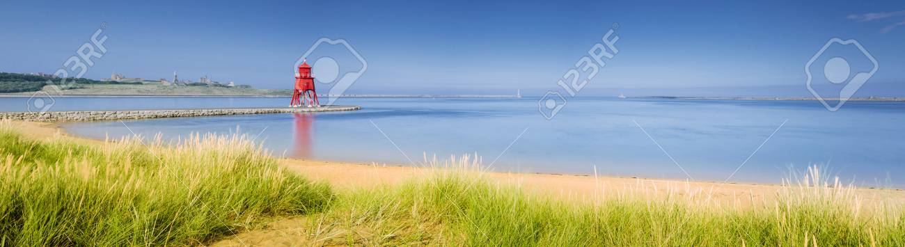 South Shields Beach panorama with the the Groyne Lighthouse sitting in the mouth of the River Tyne to protect the beach and help with navigation - 23109351 South Shields Beach panorama with the the Groyne Lighthouse sitting in the mouth of the River Tyne to protect the beach and help with navigation - 23109351