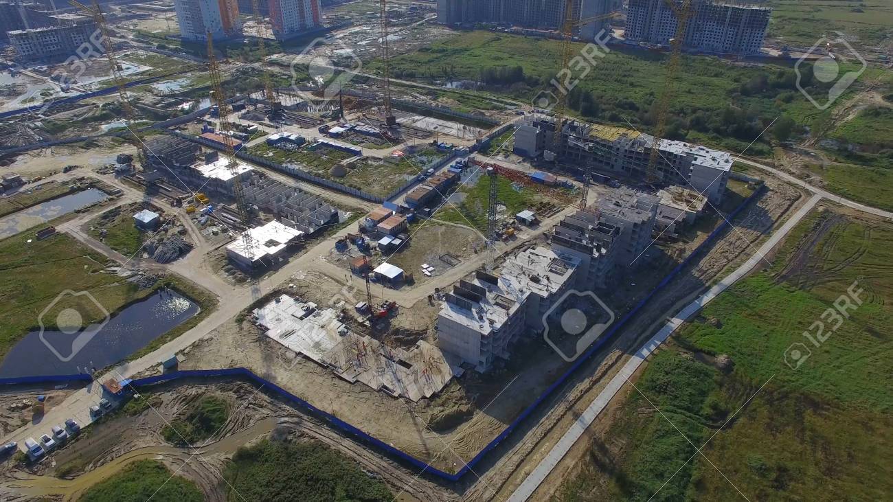 建設建物の空中写真。サイトの建設労働者、空中、トップ ビュー。大型クレーンで工事現場の俯瞰。建築現場や建築作業に折りたたまれた床の空撮。