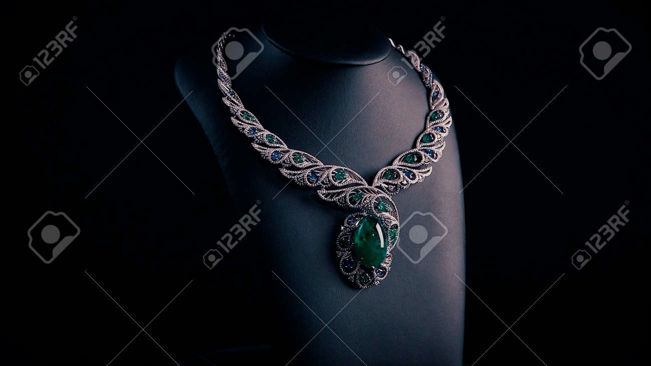 Beautiful necklace with blue sapphires and green emeralds on a black mannequin. Video. Close up of an expensive pendant of white gold and gemstones. - 170380538 Beautiful necklace with blue sapphires and green emeralds on a black mannequin. Video. Close up of an expensive pendant of white gold and gemstones. - 170380538