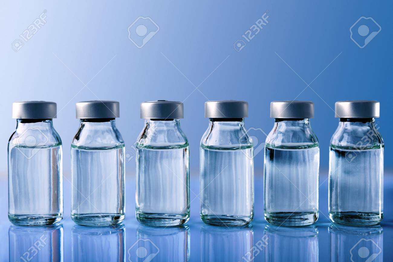 Row of vials with medication on blue methacrylate table. Horizontal composition. Front view. - 88561074 Row of vials with medication on blue methacrylate table. Horizontal composition. Front view. - 88561074