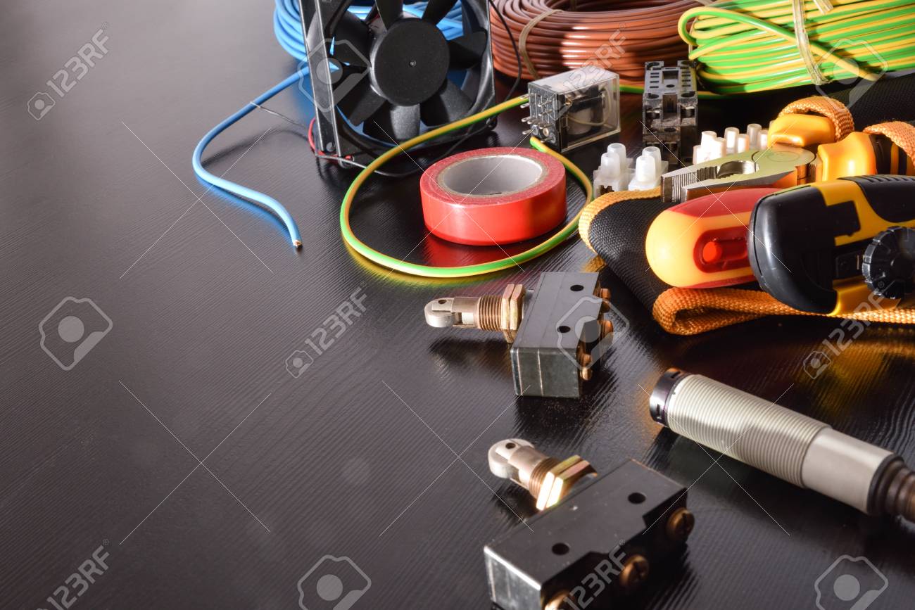 전기 패널 및 전기 기계 공간의 설치, 수리 및 유지 관리를 위한 산업 장비 및 도구가 있는 블랙 테이블이 왼쪽에 있습니다. 수평  구성. 높은 보기. 로열티 무료 사진, 그림, 이미지 그리고 스톡포토그래피.