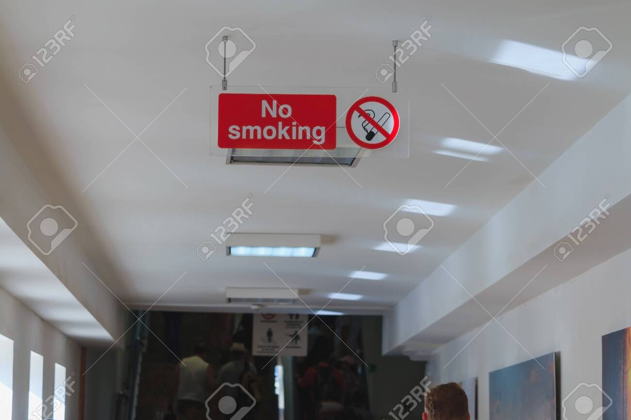Acrylic No Smoking Sign Attached On Ceiling People Walking In