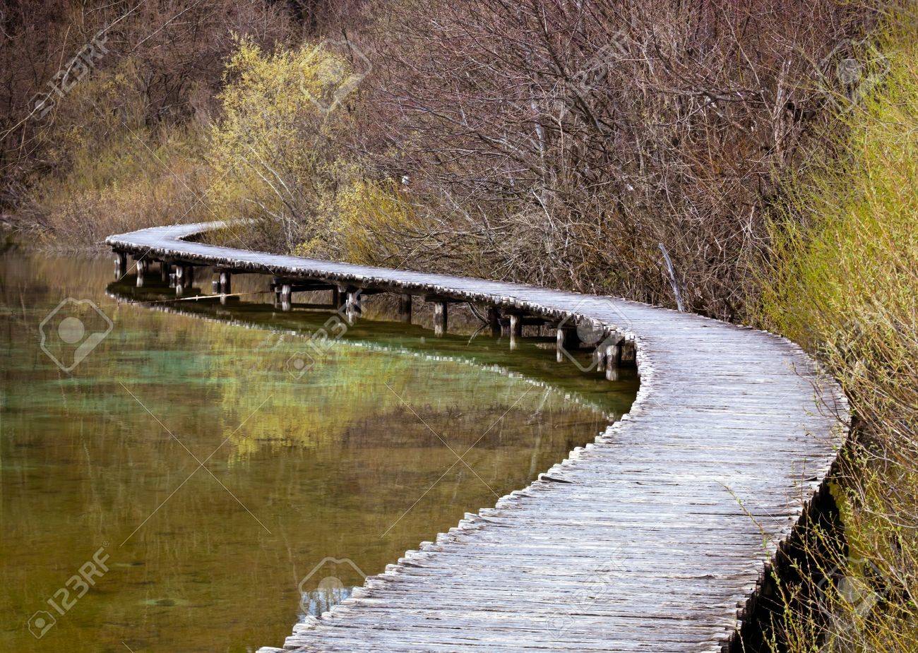 Curved wooden path in the Plitvice lakes (Plitvicka jezera) national park, Croatia, Europe. Season: Early spring. - 4700079 Curved wooden path in the Plitvice lakes (Plitvicka jezera) national park, Croatia, Europe. Season: Early spring. - 4700079