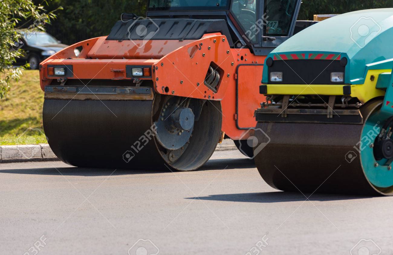 roller machine rolls fresh laid asphalt on the road in the city laid asphalt