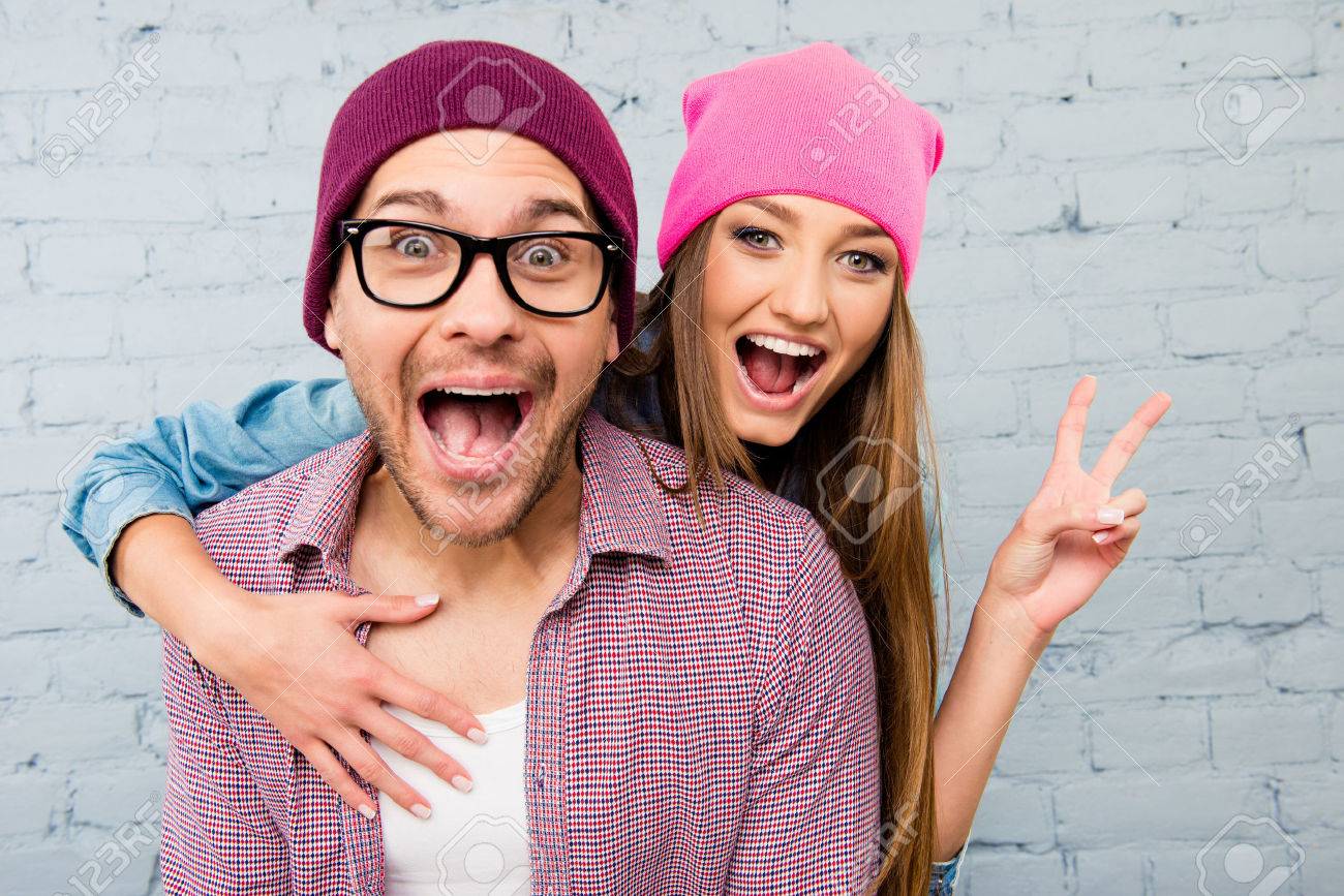 Portrait of two happy lovers in caps huging and screaming - 56189449 Portrait of two happy lovers in caps huging and screaming - 56189449