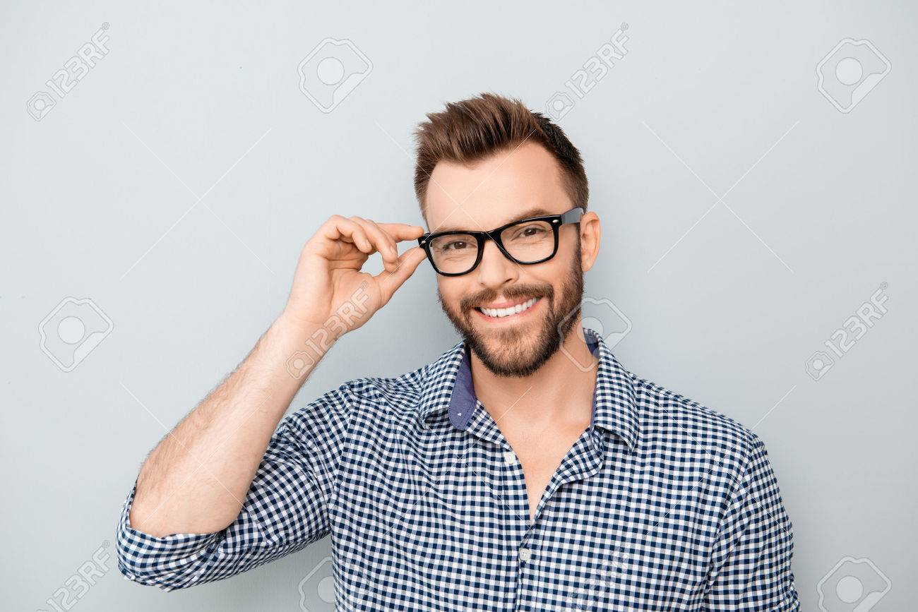 Cheerful smiling young businessman touching his glasses - 59056830 Cheerful smiling young businessman touching his glasses - 59056830