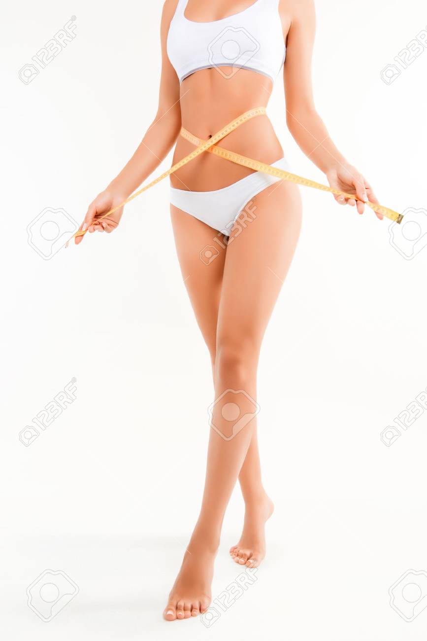 Close up of healthy woman measuting her shapely body - 61771230 Close up of healthy woman measuting her shapely body - 61771230
