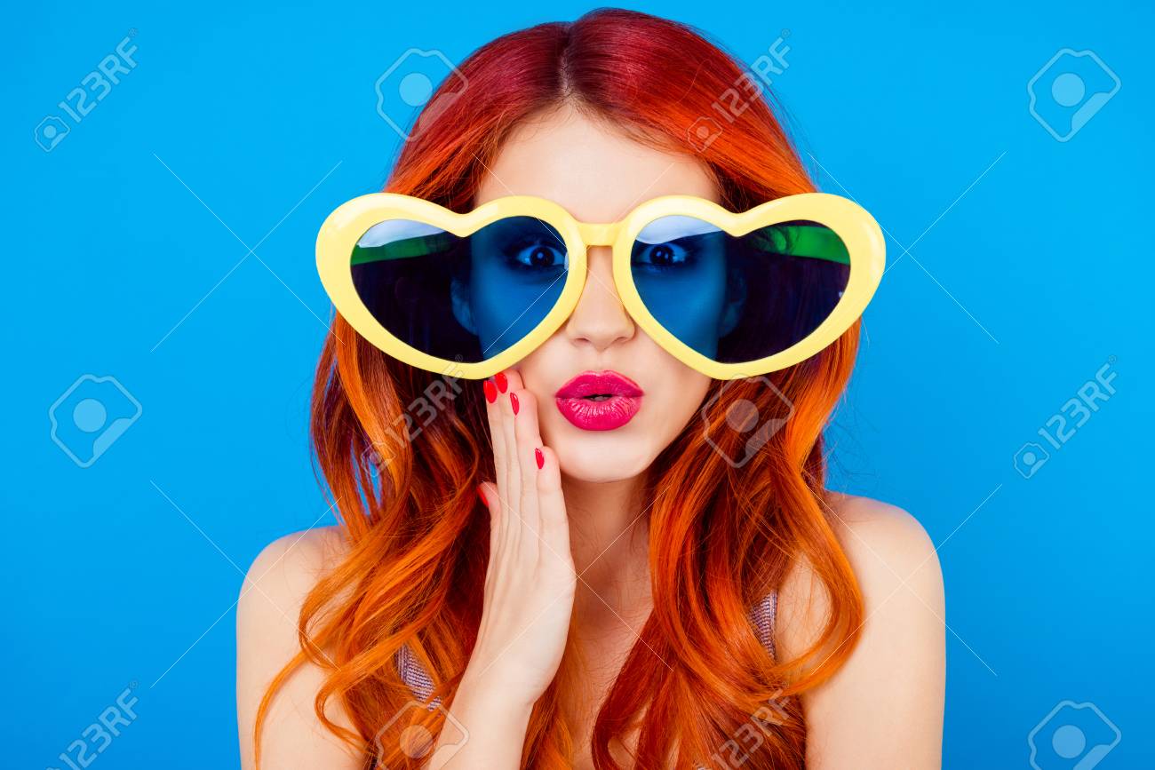 ショックで巻き毛の屈託のない陽気なかなりお洒落な魅力的な義理の肖像画 彼女はタッチ顔しながら恋に落ちるし 青の背景にカメラでハート形のような眼鏡を見て の写真素材 画像素材 Image