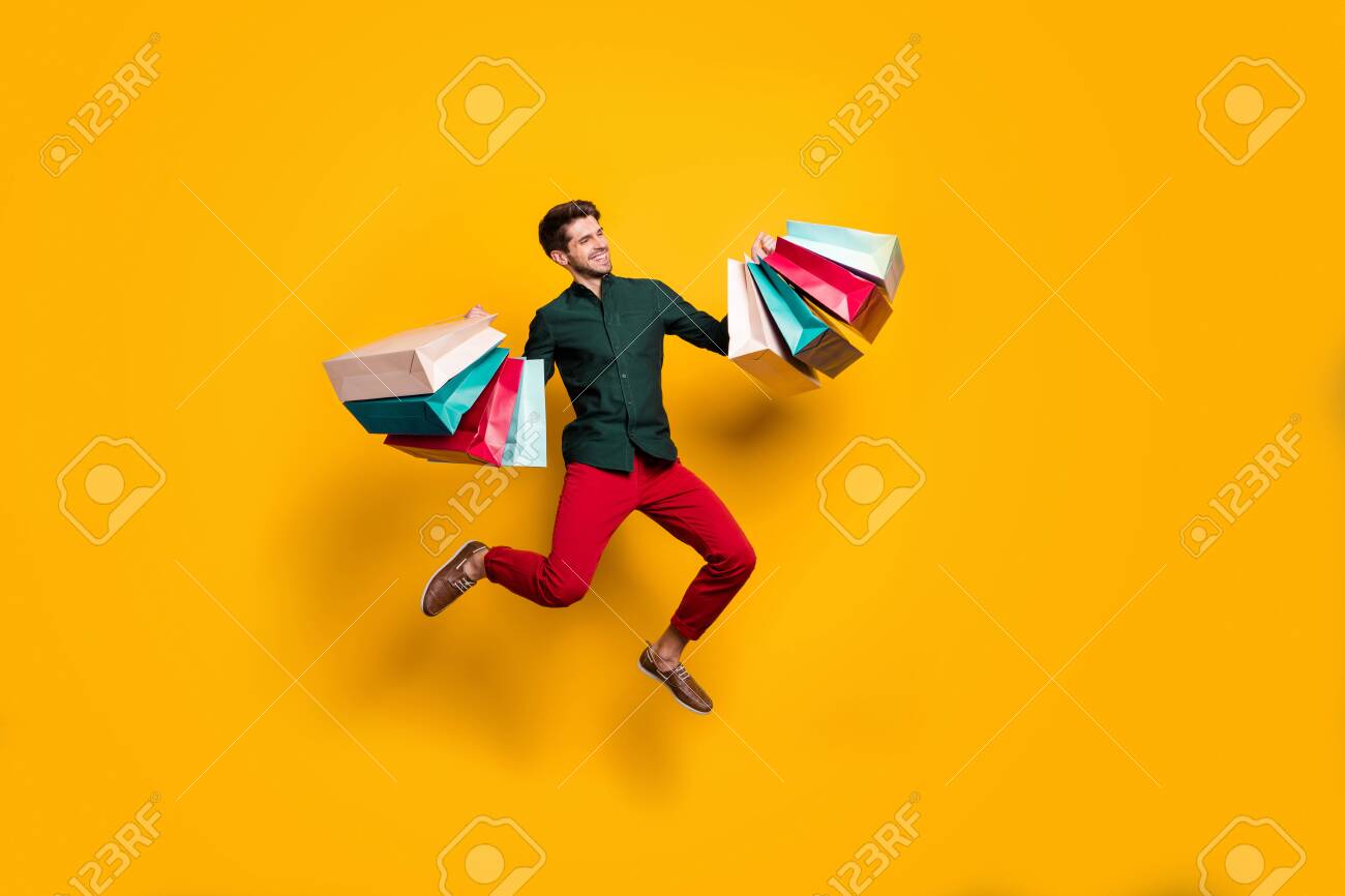 Full length body size photo of cheerful positive handsome jumping man holding numerous packages returning from shopping mall isolated vivid color background - 133739954 Full length body size photo of cheerful positive handsome jumping man holding numerous packages returning from shopping mall isolated vivid color background - 133739954