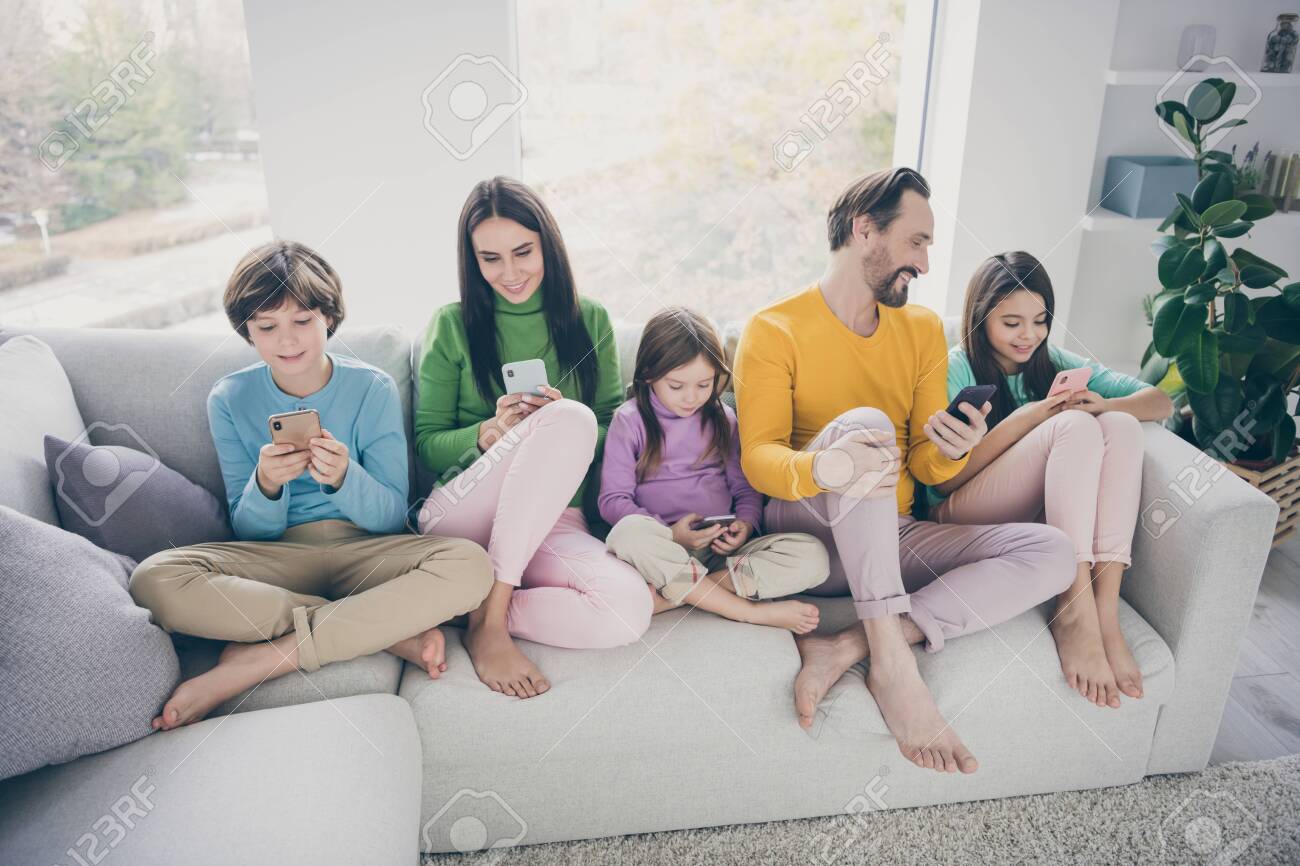 Portrait of nice attractive foot big full cheerful cheery family pre-teen kids spending free time sitting on sofa using 5g app internet online wi-fi connection at light white interior style house - 139910773 Portrait of nice attractive foot big full cheerful cheery family pre-teen kids spending free time sitting on sofa using 5g app internet online wi-fi connection at light white interior style house - 139910773