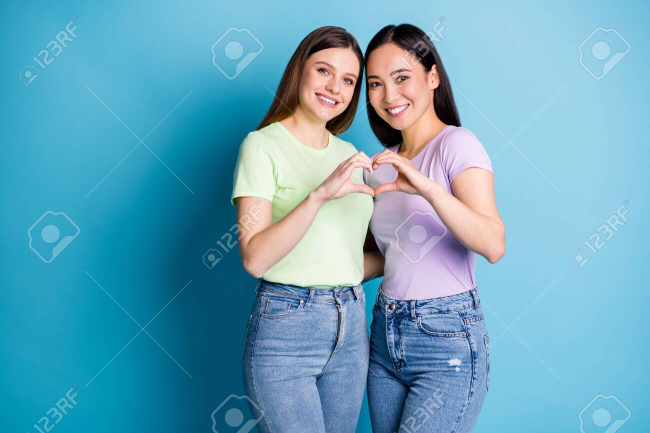 jovencitas Foto De Lesbianas Cariñosas Pareja Jovencitas Cita Romántica Hacer Brazos  Dedos Forma De Corazón Símbolo Amantes Aniversario Usar Camisetas Casuales  Jean Aislado Fondo De Color Azul Fotos, retratos, imágenes y fotografía de