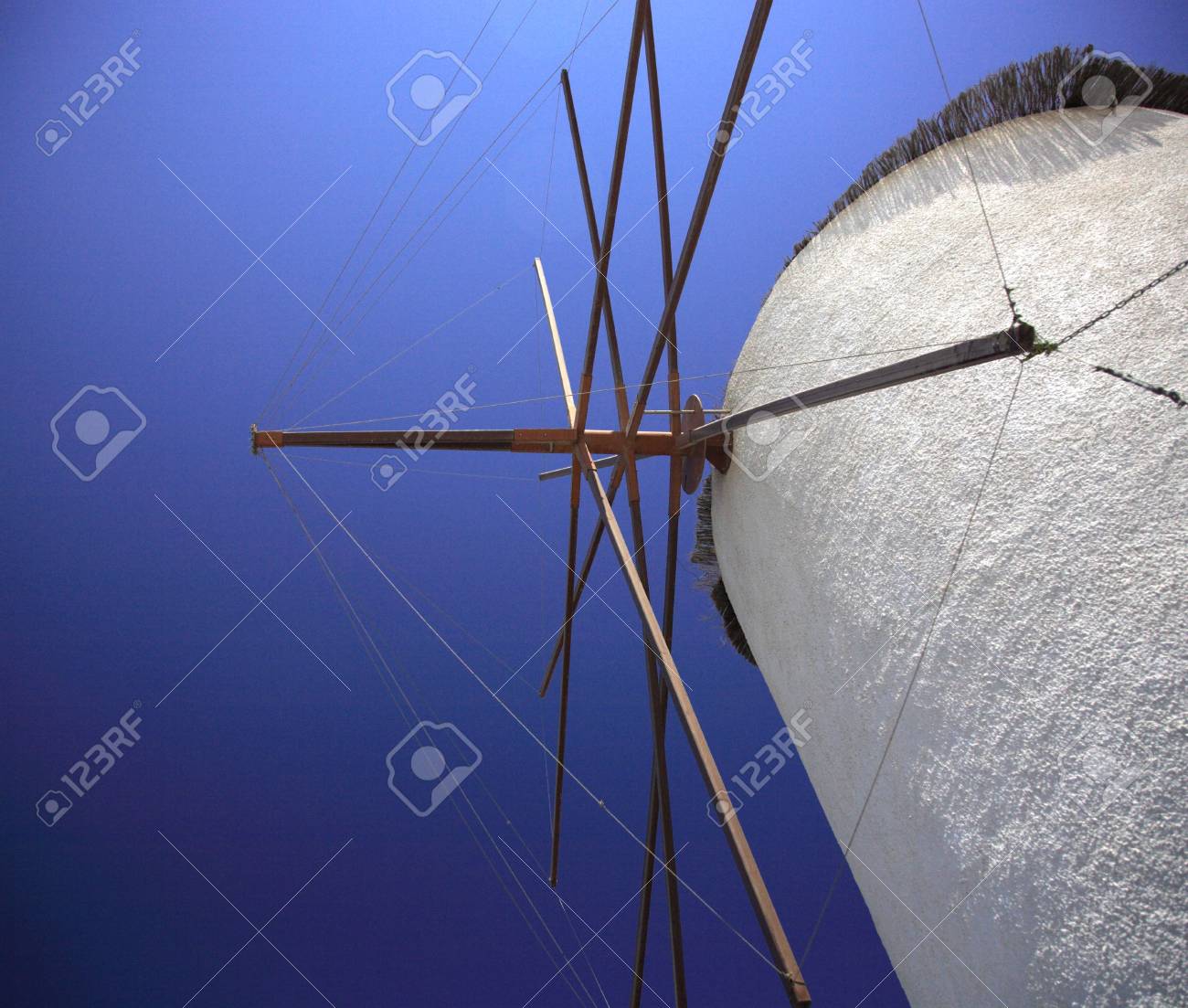 Windmill masts on a whitewashed windmill against a vivid blue sky - 897368 Windmill masts on a whitewashed windmill against a vivid blue sky - 897368
