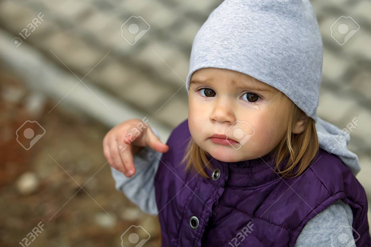 Linda Nina Triste Llorando Bebe Que Desgasta Un Sombrero Y Una Chaqueta Calientes Bebe Llorando Y Senalando A Alguien Hace Frio Y Nublado Primer Plano De La Foto Fotos Retratos Imagenes Y