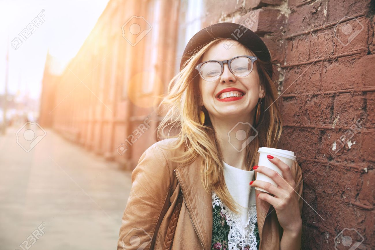 明るい日差しの中で朝のコーヒーを飲む通りの陽気な女性 の写真素材 画像素材 Image