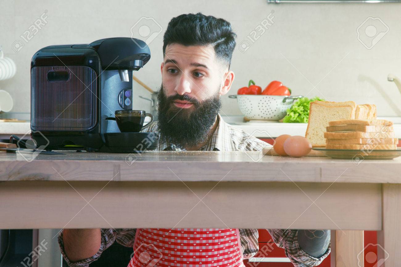 Bearded Man Making Morning Espresso With Coffee Machine While Breakfast At Kitchen Stock Photo Bearded Man Making Morning Espresso With Coffee Machine While Breakfast At Kitchen Stock Photo