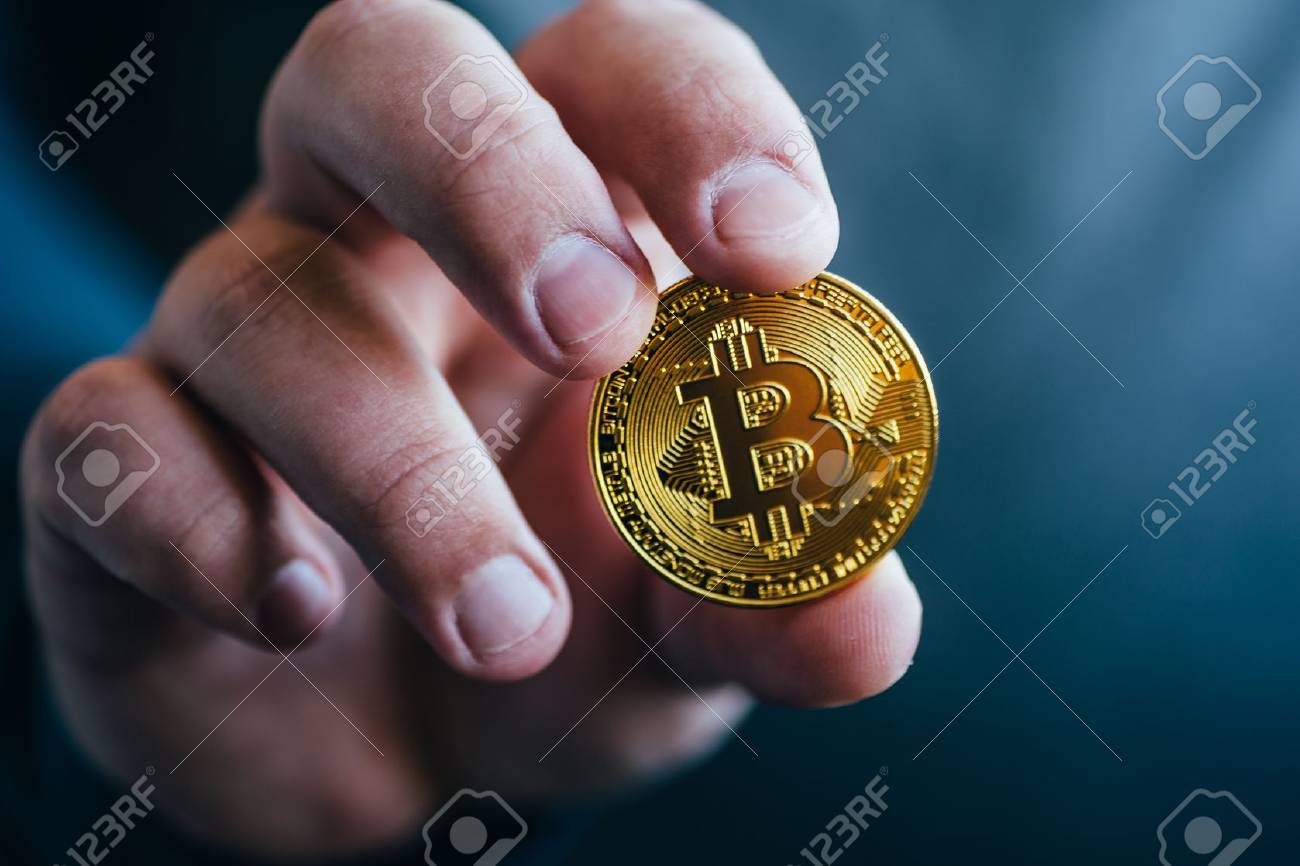 Cryptocurrency Golden Bitcoin Coin. Man Holding In Hand Symbol Of Crypto  Currency - Electronic Virtual Money For Web Banking And International  Network Payment, Selective Focus, Toned Stock Photo, Picture and Royalty  Free