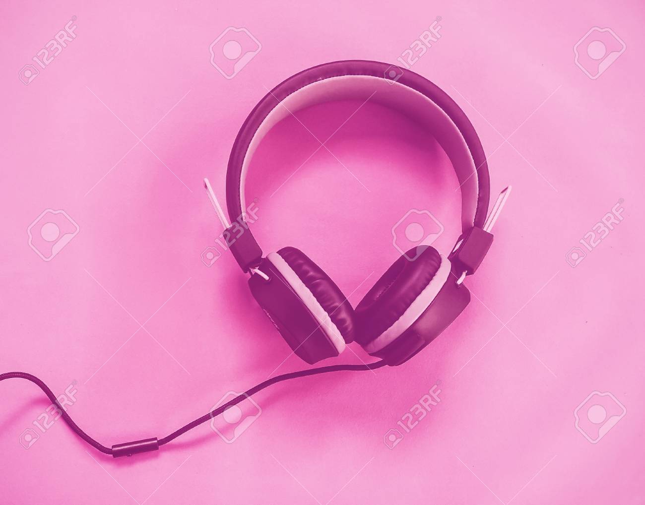 黒のヘッドフォンは ヴィンテージのピンクのトーンを分離しました の写真素材 画像素材 Image