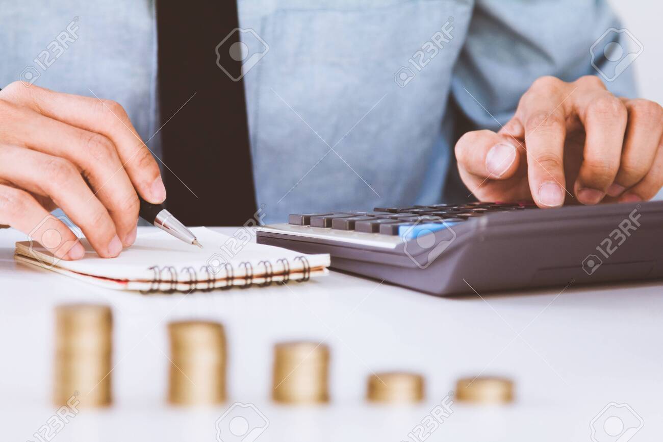 businessman hand using calculator Calculating bonus(Or other compensation) to employees to increase productivity.Writing paper on desk. - 121280670 businessman hand using calculator Calculating bonus(Or other compensation) to employees to increase productivity.Writing paper on desk. - 121280670