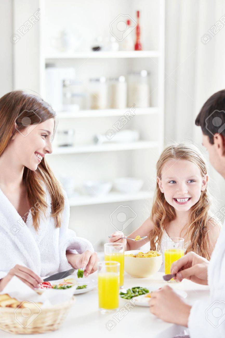 A happy family with a child eat breakfast in the kitchen - 10432036 A happy family with a child eat breakfast in the kitchen - 10432036