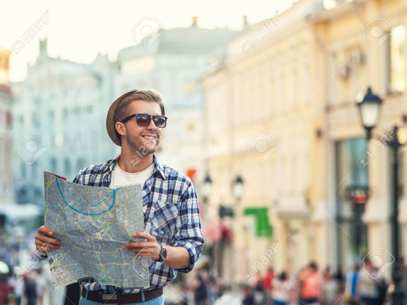 Young man with a map outdoors - 38046373 Young man with a map outdoors - 38046373